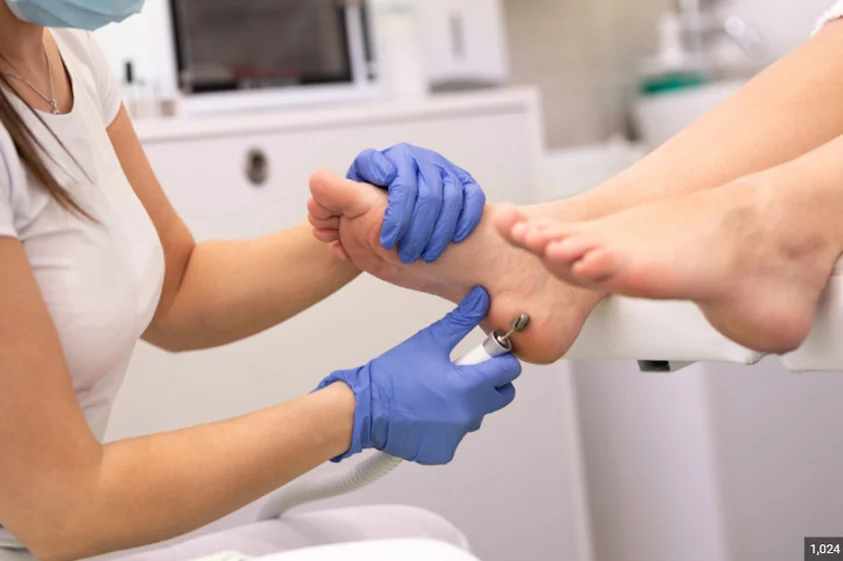podiatrist performing foot treatment on a patient
